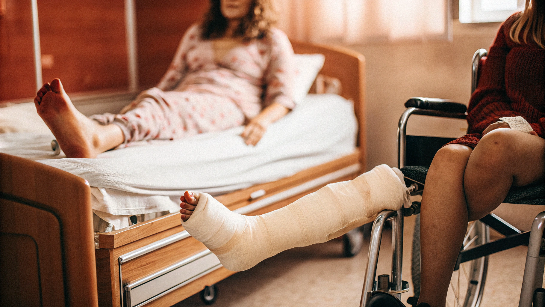 AI generated image by Red Panda AI: help me please: zwei 30 jährige Promi Frauen im Krankenhauszimmer vergleichen ihre Gipsverbände– eine mit rot lackierten Fußnägeln, ihr Gipsbein wird mit einer speziellen Vorrichtung angehoben, die andere mit weißem Nagellack sitzt im Rollstuhl an ihrer Seite, mit dicken rosa Gipsverbände an beiden Beinen. Die Luft knistert vor spürbarer Spannung.