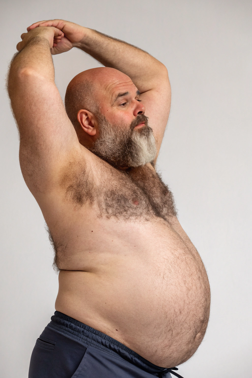 AI generated image by Red Panda AI: a studio shot of a bulky and slightly overweight 50 year old hirsute dad stretching. Man has heavy amount of body hair, hairy chest pattern, expanding his bloated heavy bearded-belly, bald head, brown and white beard