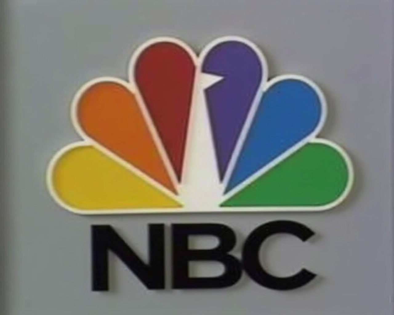 AI generated image by FLUX.1: THE LETTER N HAS BEEN REMOVED AND NOW THE PEACOCK IS SIMPLIFIED BEING JUST SIX FEATHERED ALSO ON THE BOTTOM THERE IS THE WORD "NBC" IN BLACK TEXT (1986 FOOTAGE)