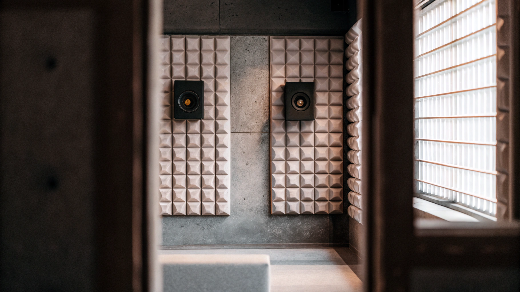 AI generated image by Red Panda AI: Radio show studio, with acoustic foam walls, pastel colors, without tables, discrete loud speakers on the walls, without any tables, showing little or no floor. 