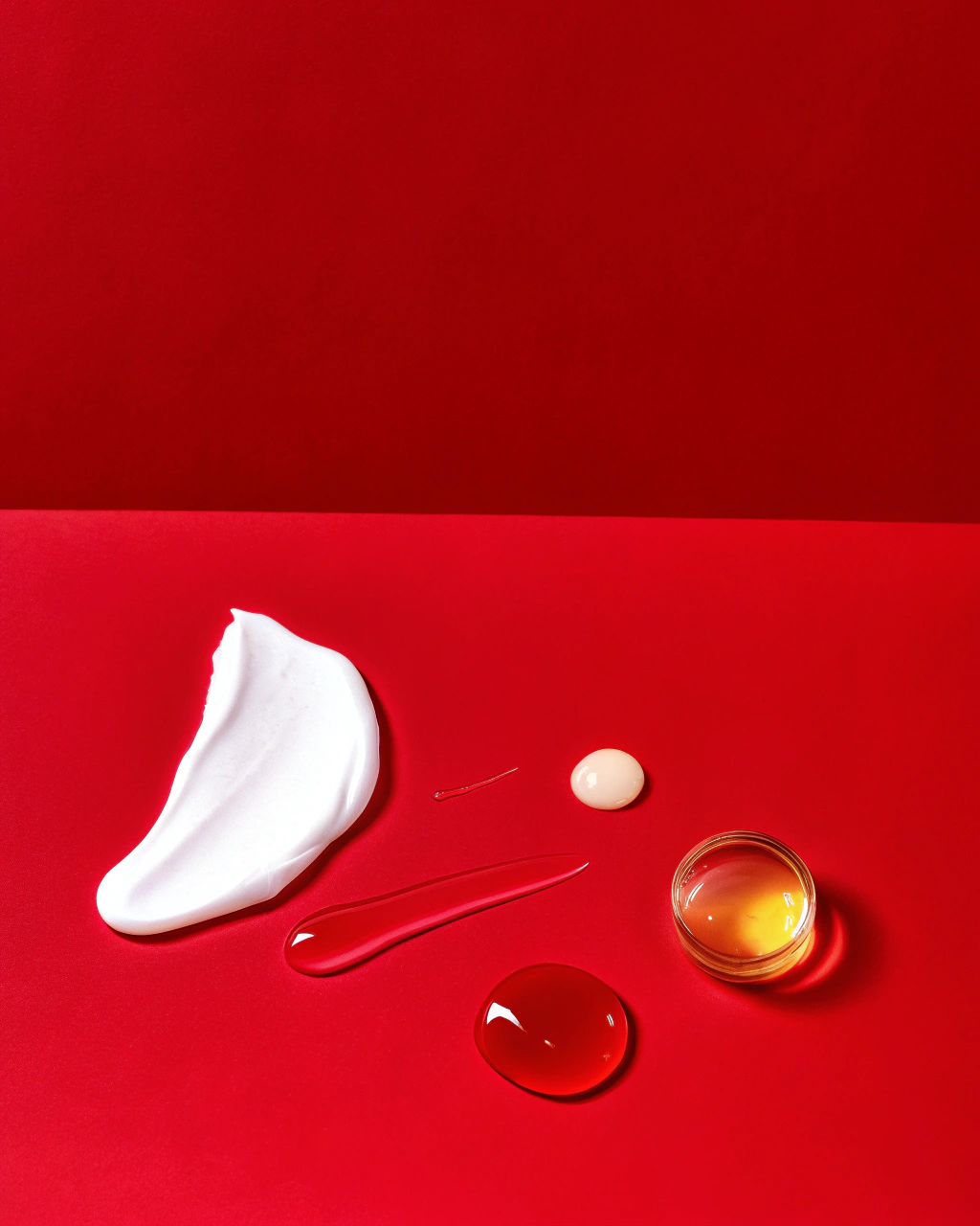 AI generated image by Red Panda AI: A minimalistic and artistic flat lay featuring natural skincare ingredients. Include a dollop of whipped tallow, a clear oil droplet, a smear of golden honey, a small puddle of amber-colored oil, and a drop of light yellow to pale amber-colored oil. Arrange these elements elegantly on a soft beige background. Use soft lighting to highlight textures and transparency, creating a clean, luxurious, and natural aesthetic.