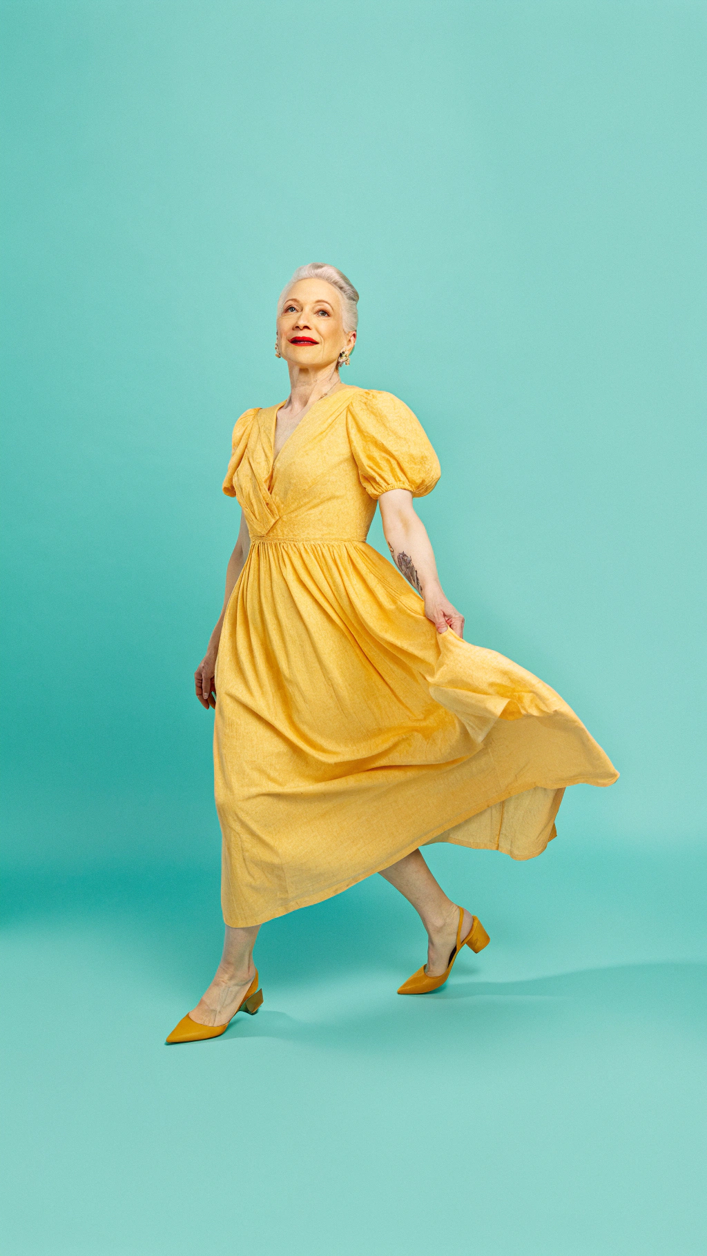 AI generated image by Red Panda AI: Mujer hermosa con cabello casi plateado, piel blanca, elegante, pose femenina, modelo usando un vestido de verano elegante y con colores vibrantes pero su base es crema, lleva pintado los labios de un rojo encendido, ojos claros miel grandes y expresivos, imagen de cuerpo completo, vista de arriba hacia abajo, caminando sobre un puente famoso de Europa con lago o río y barcos a los lados, despierta la mirada de todos y tiene enamorada a la cámara con su elegancia y feminidad.