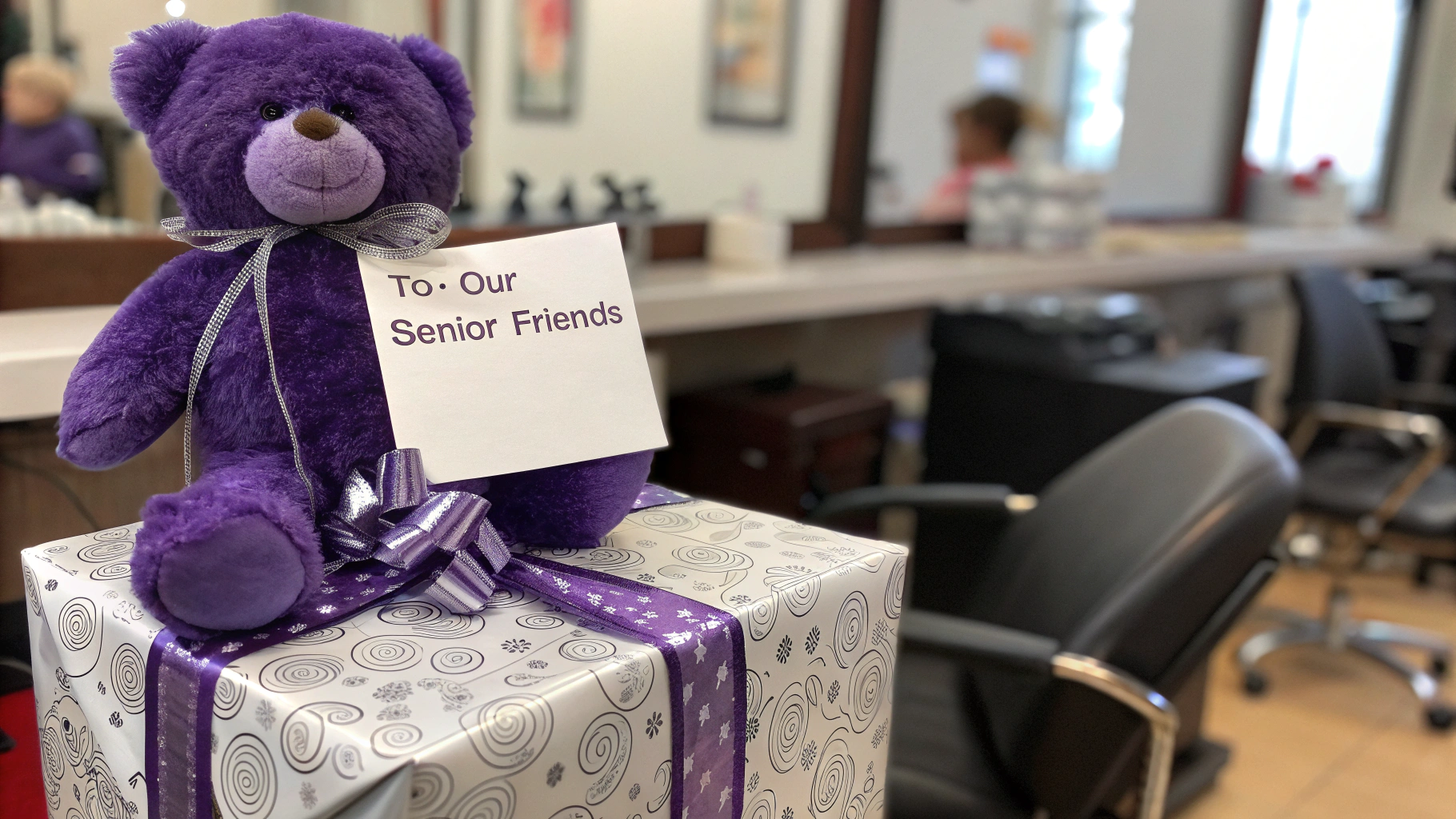 AI generated image by Red Panda AI: a staged photo that shows a purple teddy bear sitting on a wrapped holiday gift (perhaps in silver and white paper to complement the purple and maintain the Blair school colors). The gift could be positioned on a salon styling station with professional styling tools tastefully blurred in the background, creating a connection between the salons and the giving program. A simple gift tag visible in the photo could read "To: Our Senior Friends." 