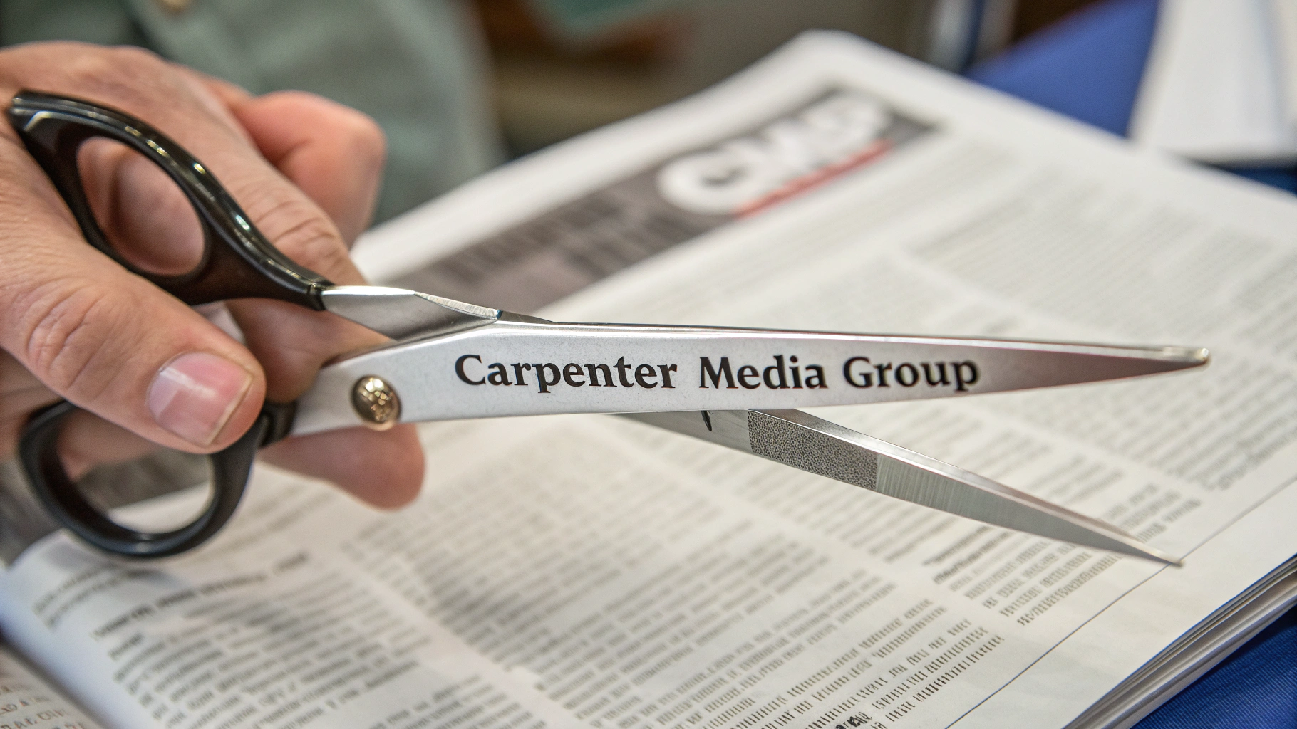 AI generated image by Red Panda AI: clean scissors with "Carpenter Media Group" engraved on them, being used to cut a newspaper, the scissors have "Carpenter Media Group" on the side