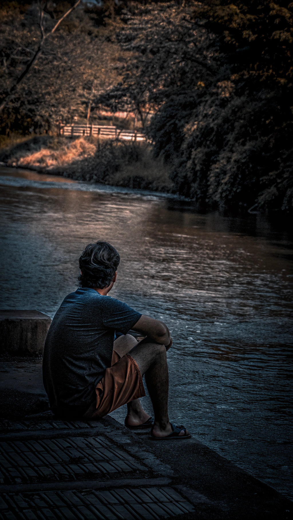 AI generated image by Red Panda AI: seorang lelaki sedang duduk dipinggir sungai