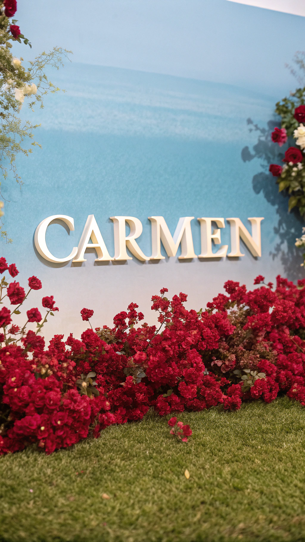 AI generated image by Red Panda AI: NAME TEXT "CARMEN " IN WHITE COLOR AND GOLDEN EDGES WITH RED FLOWERS AROUND AND A BEAUTIFUL BLUE GRADIENT BACKGROUND