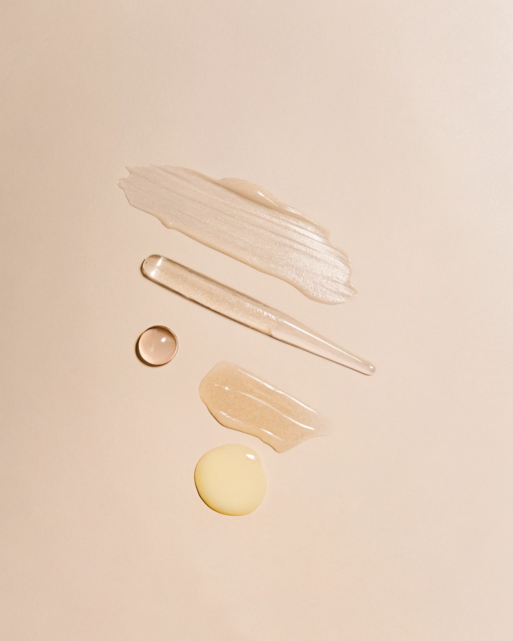 AI generated image by Red Panda AI: A minimalistic and artistic flat lay featuring natural skincare ingredients. Include a dollop of whipped tallow, a clear oil droplet, a smear of golden honey, a small puddle of amber-colored oil, and a drop of light yellow to pale amber-colored oil. Arrange these elements elegantly on a soft beige background. Use soft lighting to highlight textures and transparency, creating a clean, luxurious, and natural aesthetic.