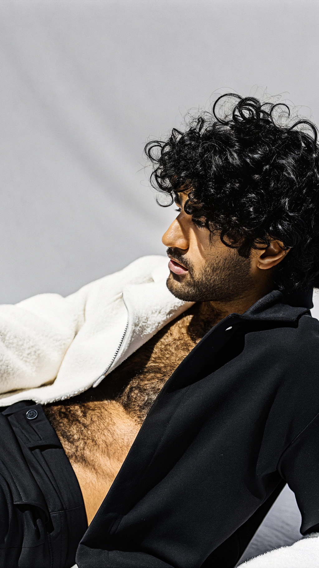 AI generated image by Red Panda AI: close up portrait of a handsome arab male model posing wearing black briefs, he has black curly hair, gray studio background, detailed skin texture, very hairy body