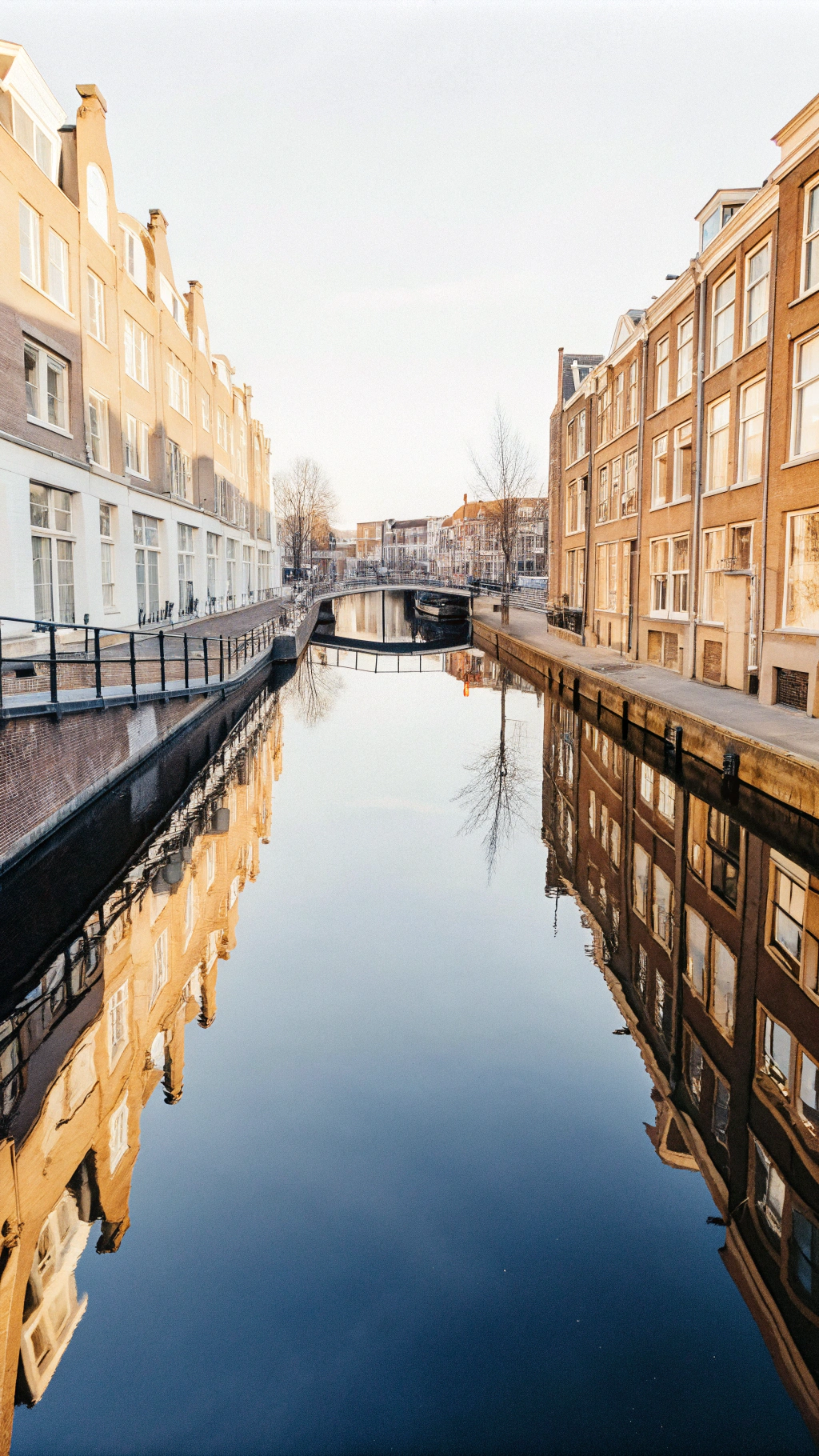 AI generated image by FLUX.1-schnell: A Birds Eye image looking directly down onto a dutch canal from the height of an aircraft in the evening light