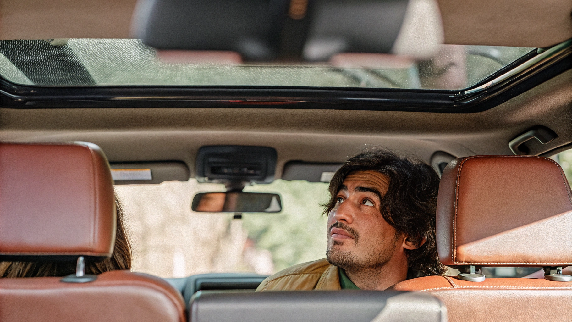AI generated image by Red Panda AI: A realistic photo shows a 30-year-old man in the driver's seat of a 2024 TACOMA. The camera capturing this image is positioned outside directly in front of the cars front bumper, slightly elevated to look into the interior through the front windscreen. The focus is on the clean, obstacle-free interior, clearly showing the passenger seat and back seats. Cinematic lighting provides a well-lit view