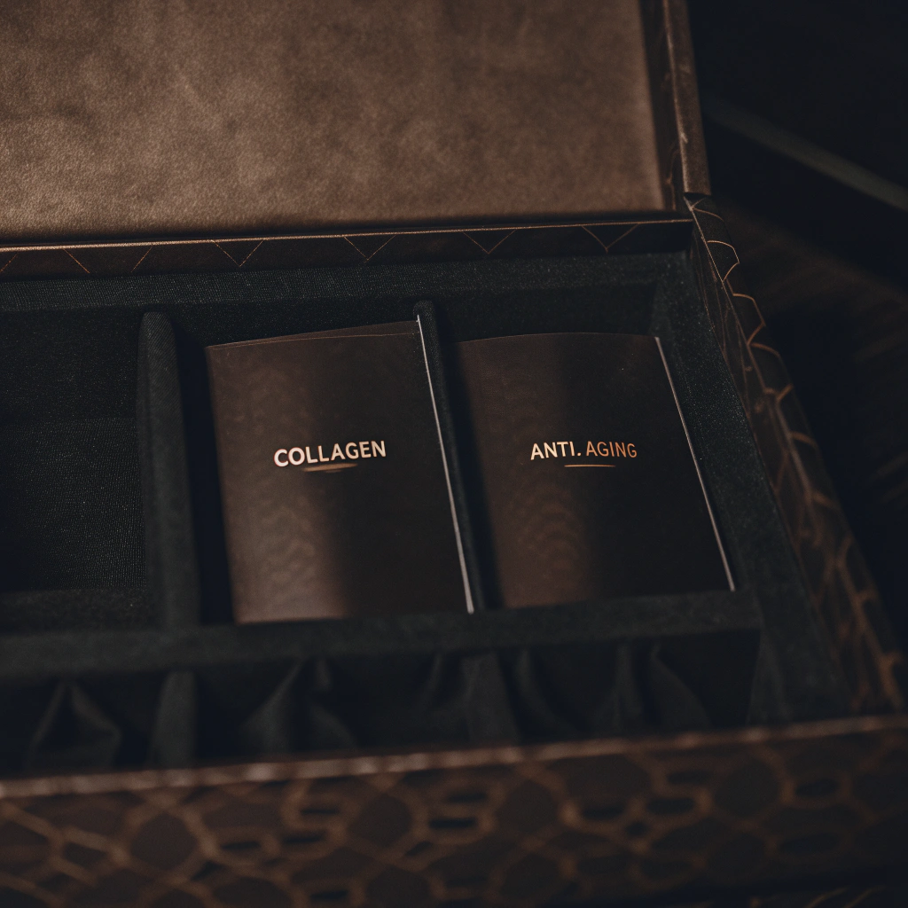 AI generated image by Red Panda AI: “为一款次抛胶原蛋白保湿抗皱精华设计包装:整体以红色和金色为主色调,展现高端、奢华的视觉氛围。外包装采用高级红哑光纸盒,辅以烫金品牌标志和浮雕压纹细节,局部使用丝绒质感或UV光油工艺来增强触感。包装盒可为天地盖或翻盖礼盒,内部用整洁的托盘或抽屉式设计固定小容量安瓶。安瓶瓶身为透明或半透明的红色玻璃(或塑料),金色丝印文字或烫金标识,突出‘Collagen’和‘Anti-Aging’等关键词,表现出专业、时尚、精致。希望整体呈现简约大气的高级感。”
提示要点
核心元素:红色与金色、哑光/丝绒质感、烫金/UV、浮雕压纹、简洁大气。
包装结构:天地盖或翻盖式礼盒 + 内部托盘/抽屉;小容量安瓶单独固定。
文字及图案:突出胶原蛋白(Collagen)、抗皱(Anti-Aging)等关键字眼。
氛围:高端、专业、奢华。