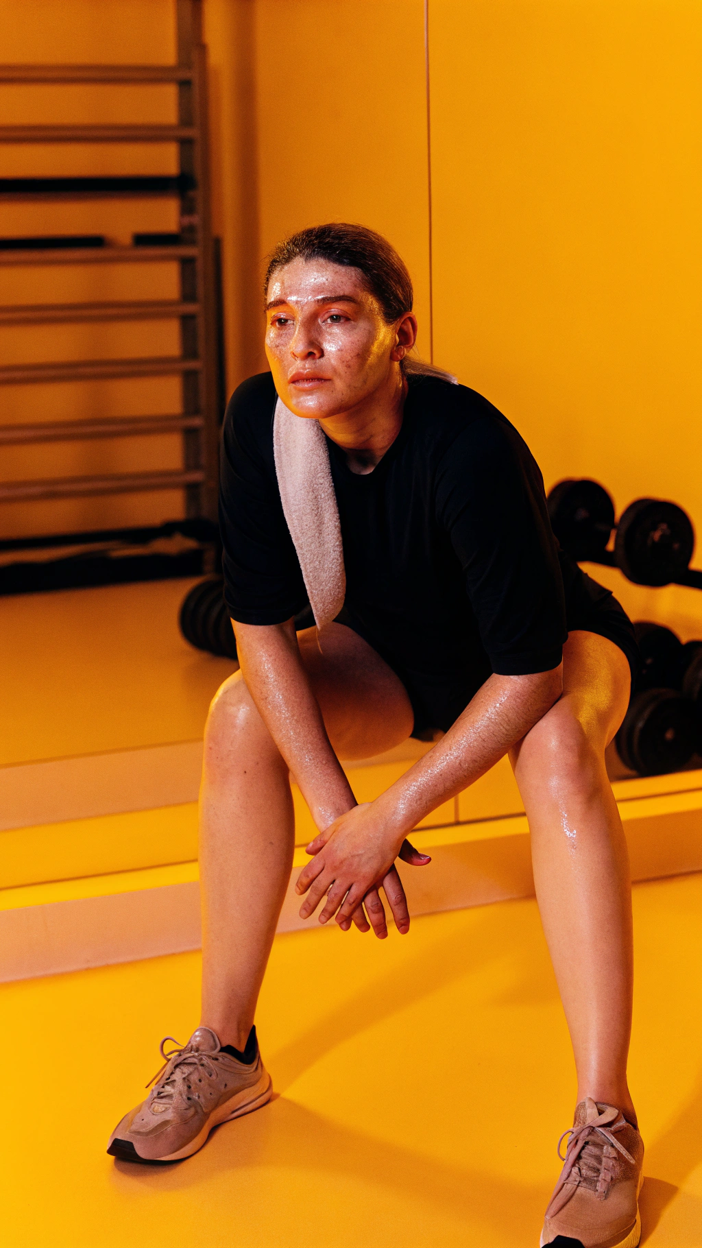 AI generated image by Red Panda AI: gimnasio oscuro (tonos fríos, con algo de calidez dorada).Un plano de medio cuerpo, con sudor en la cara o manos en las rodillas.
Que se vea que no está vencido, solo pensando seguir.