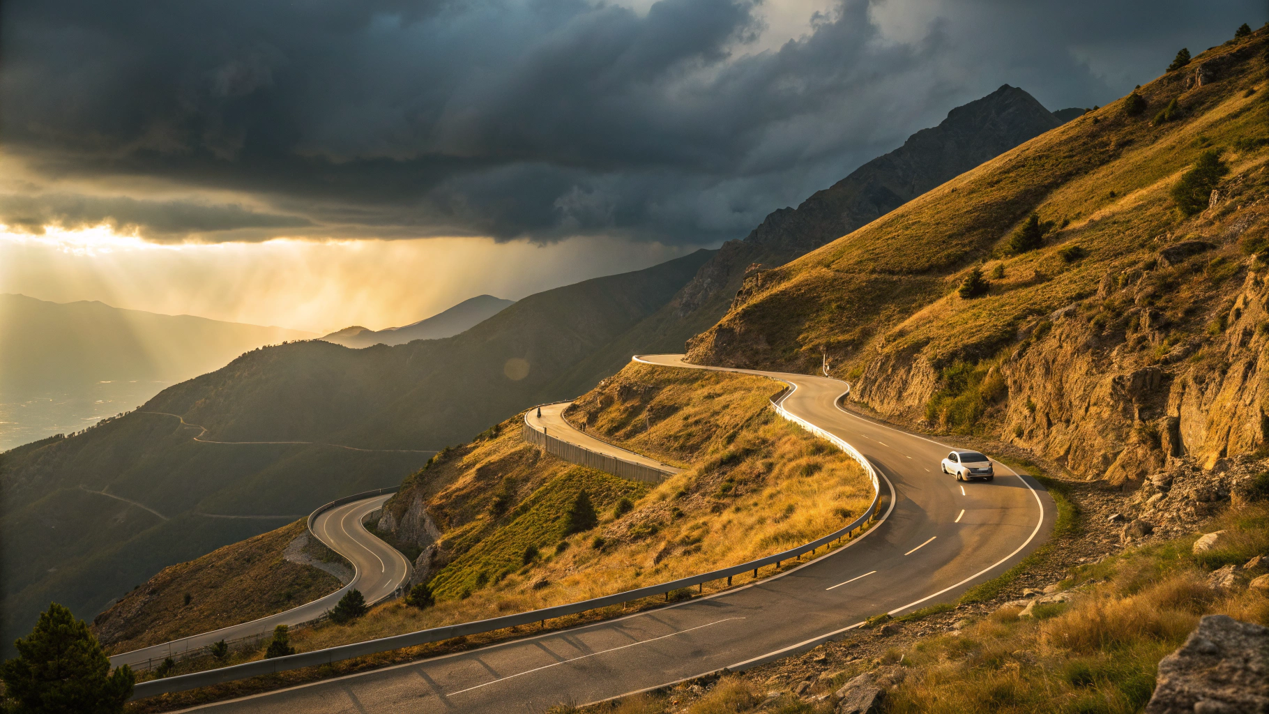 AI generated image by Red Panda AI: A winding mountain road with sharp switchbacks during changing weather conditions - one side bathed in golden sunlight while storm clouds gather on the other, with a lone vehicle navigating the turns. Dramatic lighting, cinematic perspective, photorealistic.