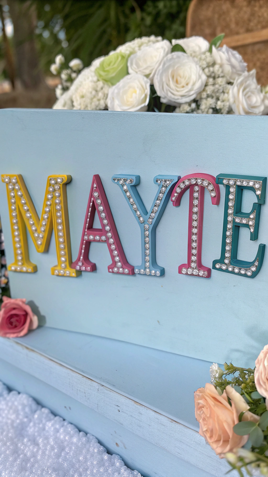 AI generated image by Red Panda AI: Mayte’s name written in vibrant colors, with diamonds on the letters, the letter “M” in uppercase, a light blue background, and a romantic style.